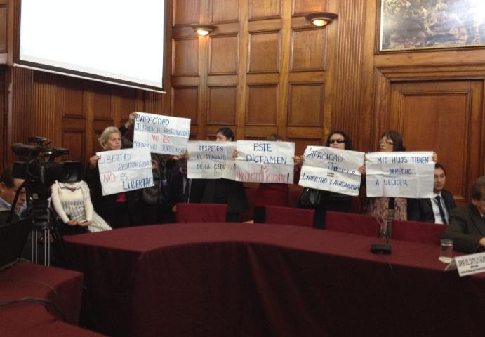 Imagen de representantes de las organizaciones de Perú en una sala, sosteniendo carteles alusivos a los derechos de las personas con discapacidad
